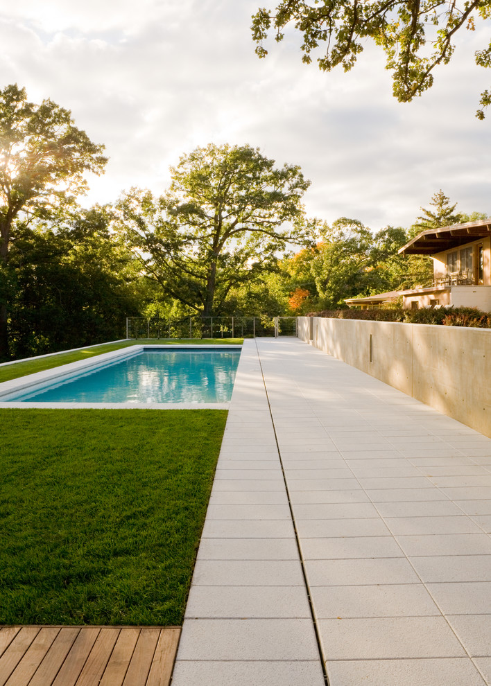 Mid-sized modern backyard rectangular pool in Minneapolis with concrete pavers.