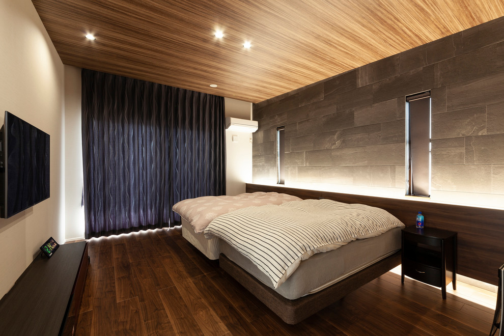 Mid-sized asian bedroom in Other with multi-coloured walls, dark hardwood floors and brown floor.
