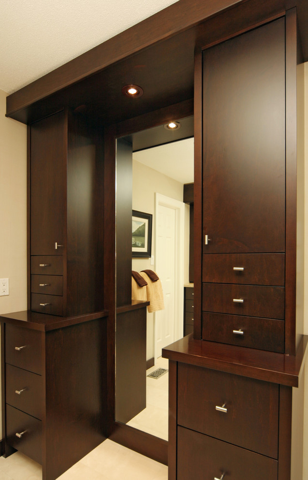 Mid-sized contemporary gender-neutral dressing room in Toronto with flat-panel cabinets, dark wood cabinets and porcelain floors.