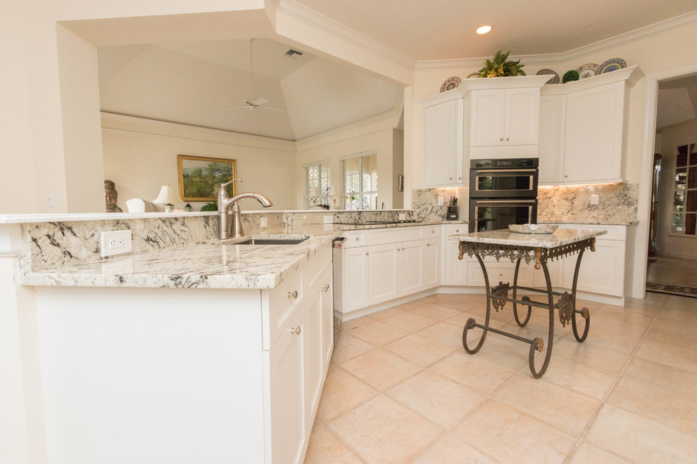 Large transitional porcelain tile eat-in kitchen photo in Miami with an undermount sink, shaker cabinets, white cabinets, granite countertops, gray backsplash, stone slab backsplash, black appliances and an island