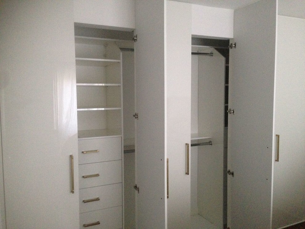 Inspiration for a mid-sized traditional built-in wardrobe in Toronto with recessed-panel cabinets and white cabinets.