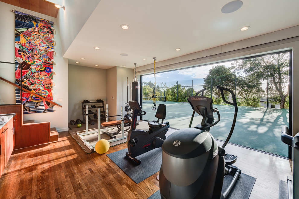 Mid-sized contemporary multipurpose gym in San Francisco with white walls, medium hardwood floors and brown floor.