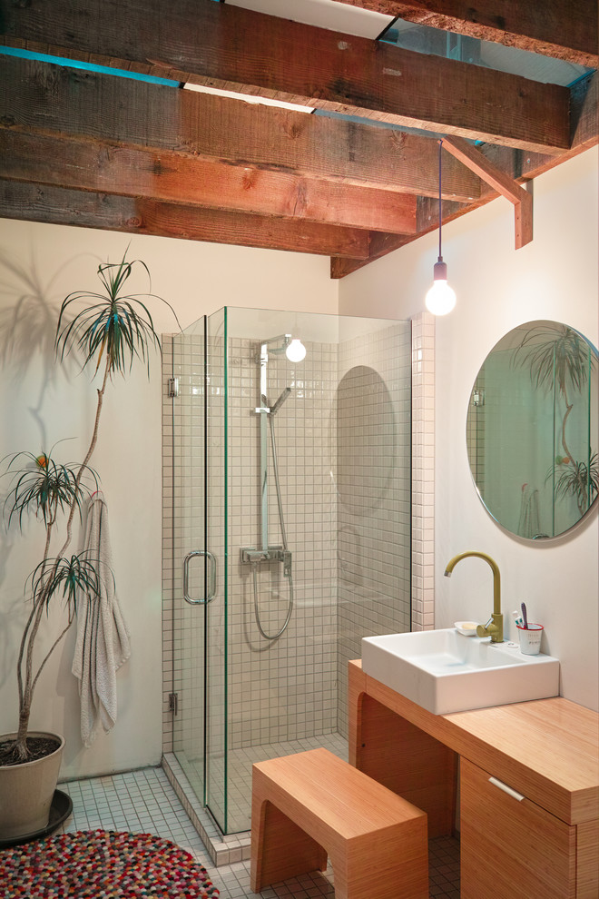 Photo of an industrial bathroom in Christchurch with a vessel sink, flat-panel cabinets, medium wood cabinets, a corner shower, beige tile, mosaic tile and mosaic tile floors.