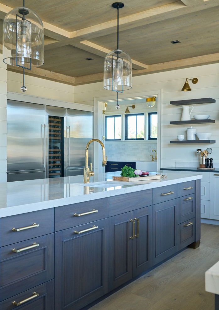 Inspiration for an industrial u-shaped open plan kitchen in New York with a farmhouse sink, recessed-panel cabinets, blue cabinets, quartz benchtops, white splashback, shiplap splashback, stainless steel appliances, light hardwood floors, multiple islands, beige floor, white benchtop and wood.