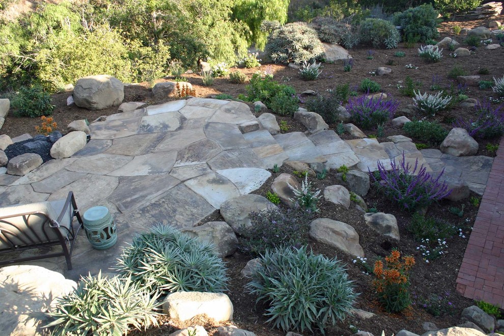 Inspiration for a mid-sized mediterranean backyard partial sun outdoor sport court in Santa Barbara with natural stone pavers.