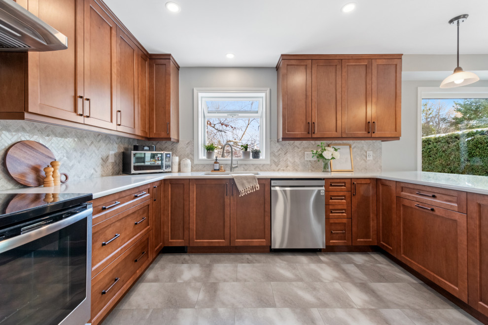 Design ideas for a mid-sized transitional u-shaped kitchen in Ottawa with an undermount sink, shaker cabinets, medium wood cabinets, quartz benchtops, brown splashback, marble splashback, stainless steel appliances, vinyl floors, brown floor and brown benchtop.