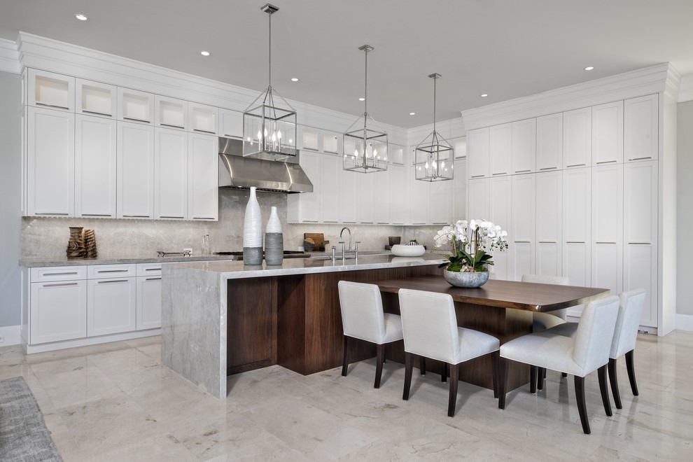 This is an example of an expansive contemporary l-shaped eat-in kitchen in Miami with shaker cabinets, white cabinets, grey splashback, with island, beige floor and grey benchtop.