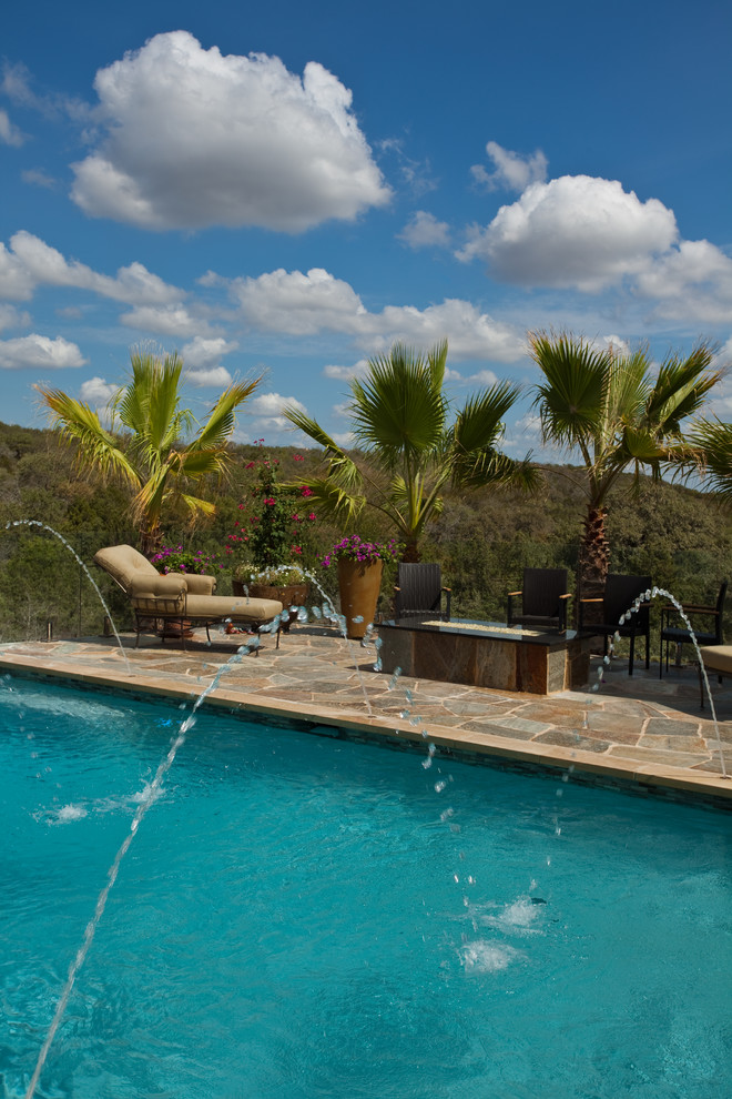Inspiration for a mid-sized rustic backyard stone and rectangular infinity pool remodel in Austin