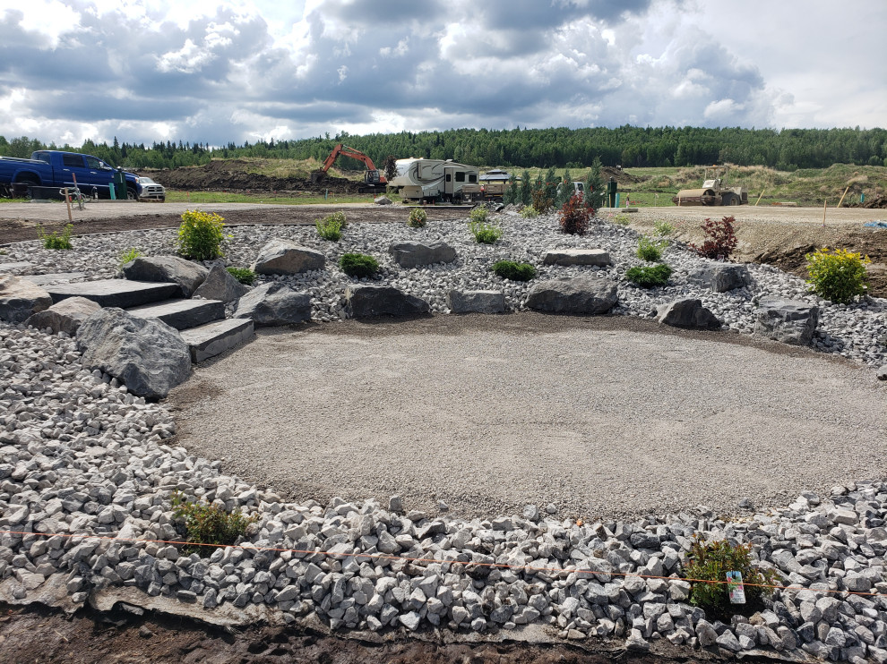 Photo of a large rustic full sun backyard concrete paver flower bed in Edmonton for summer.