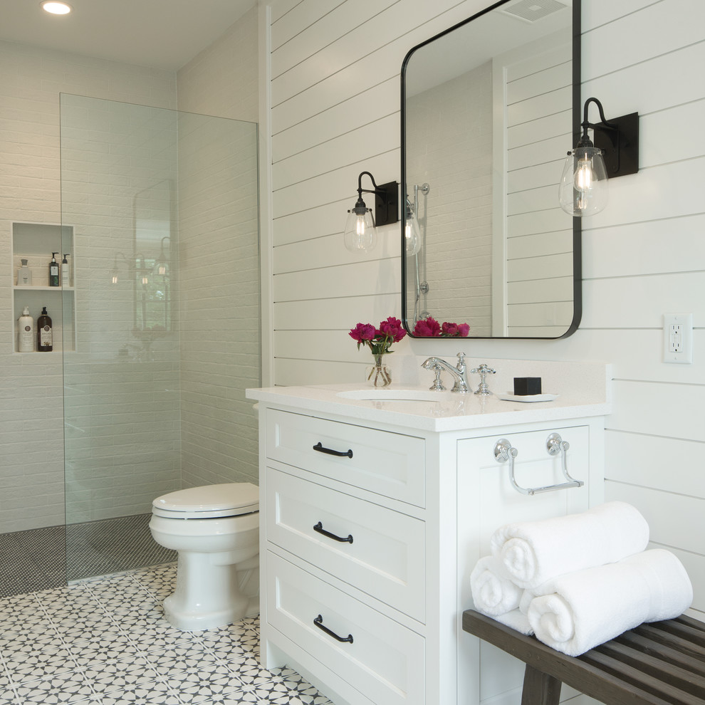 Beach style 3/4 bathroom in Minneapolis with engineered quartz benchtops, recessed-panel cabinets, white cabinets, a curbless shower, white tile, white walls, an undermount sink, white floor, an open shower and white benchtops.