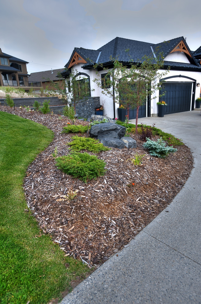 This is an example of a mid-sized traditional front yard driveway in Calgary.