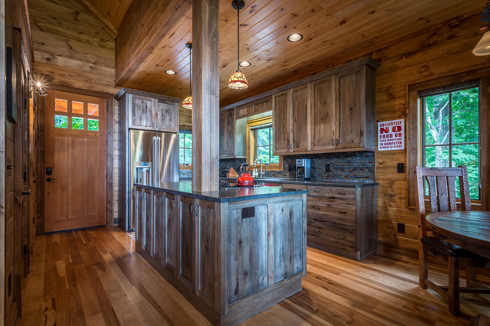 Inspiration for a mid-sized rustic l-shaped medium tone wood floor and brown floor eat-in kitchen remodel in Charlotte with an undermount sink, shaker cabinets, dark wood cabinets, granite countertops, multicolored backsplash, glass tile backsplash, stainless steel appliances and an island