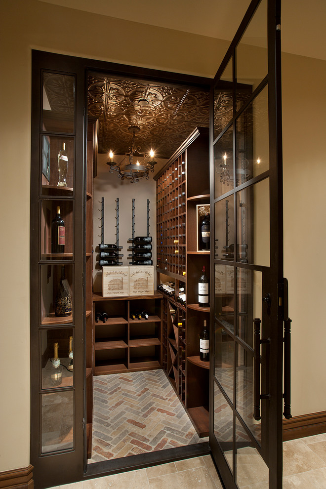 This is an example of a small mediterranean wine cellar in Phoenix with brick floors, storage racks and multi-coloured floor.