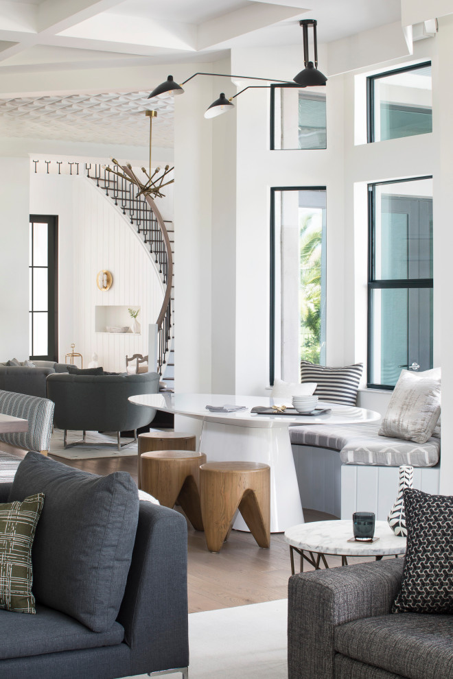 Transitional dining room in Miami with white walls, medium hardwood floors and brown floor.