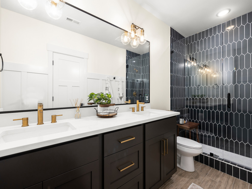 Mid-sized transitional bathroom in Other with shaker cabinets, black cabinets, an alcove shower, a one-piece toilet, black tile, ceramic tile, white walls, an undermount sink, engineered quartz benchtops, brown floor, a hinged shower door, white benchtops, a double vanity, a built-in vanity and wood-look tile.
