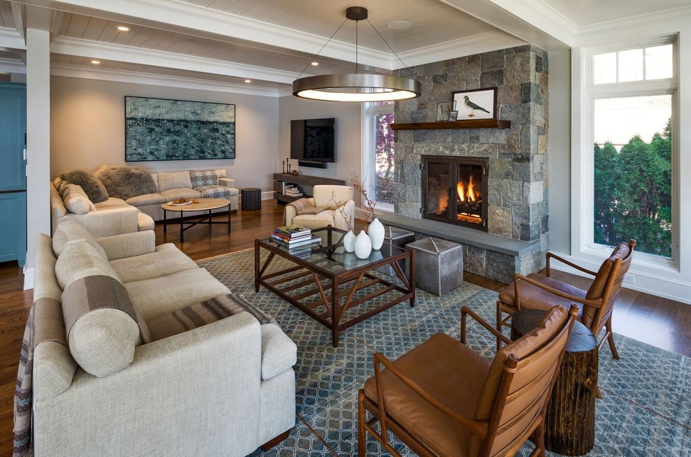 Large country open concept living room in Boston with medium hardwood floors, a standard fireplace, a stone fireplace surround, beige walls and brown floor.