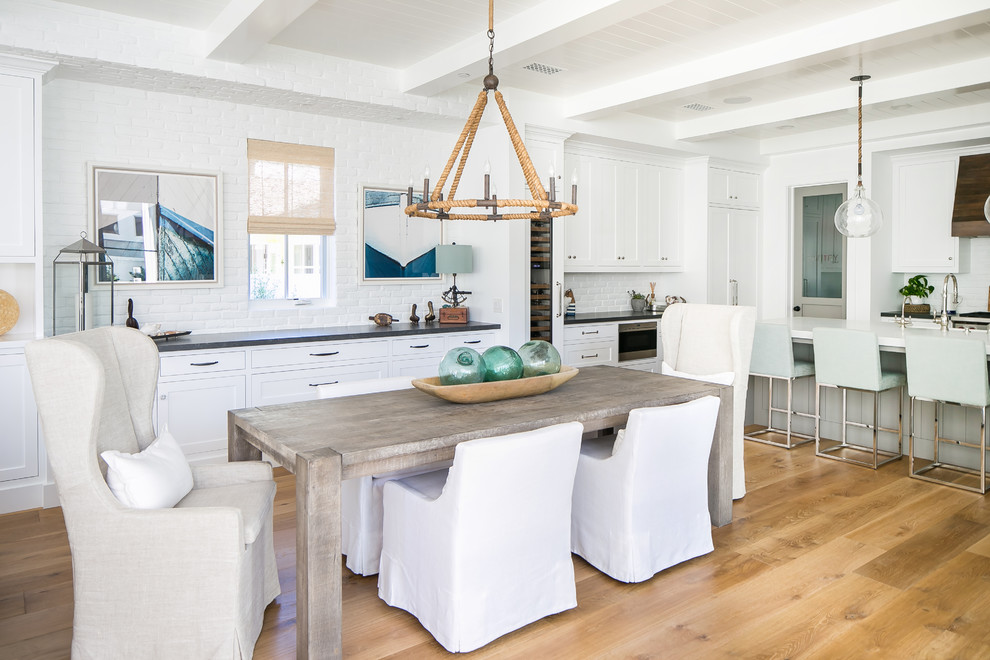Photo of a beach style kitchen/dining combo in Orange County with white walls, light hardwood floors and no fireplace.