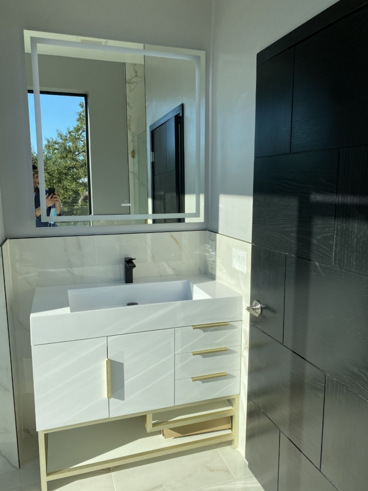 Large contemporary master bathroom in Los Angeles with flat-panel cabinets, white cabinets, a freestanding tub, a one-piece toilet, white tile, marble, grey walls, marble floors, an undermount sink, marble benchtops, white floor, a hinged shower door, white benchtops, an enclosed toilet, a single vanity, a freestanding vanity, decorative wall panelling and an alcove shower.