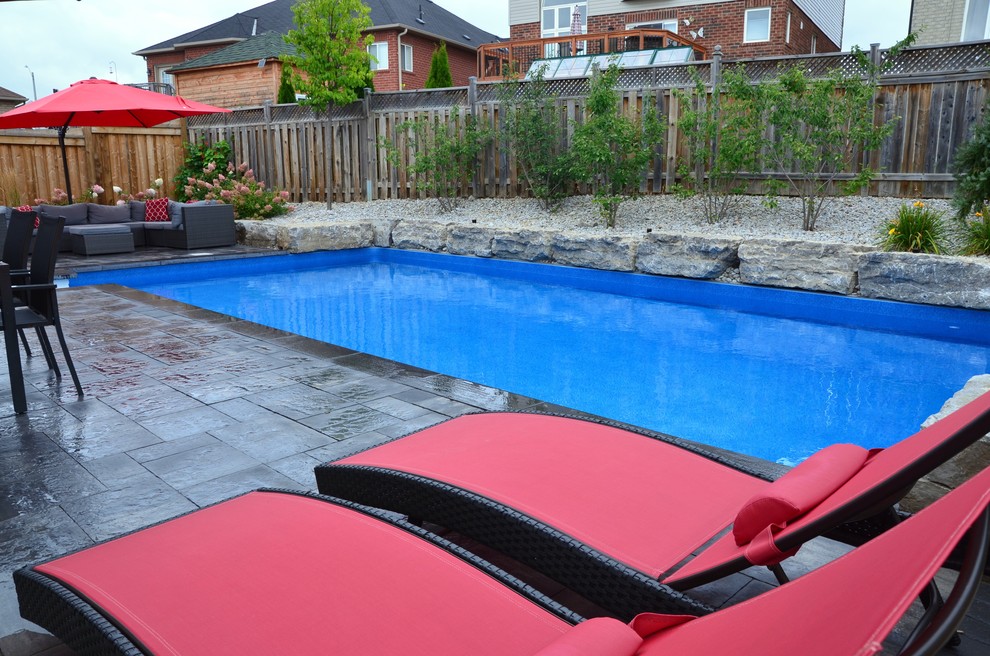 Pool - mid-sized transitional backyard concrete paver and rectangular lap pool idea in Toronto