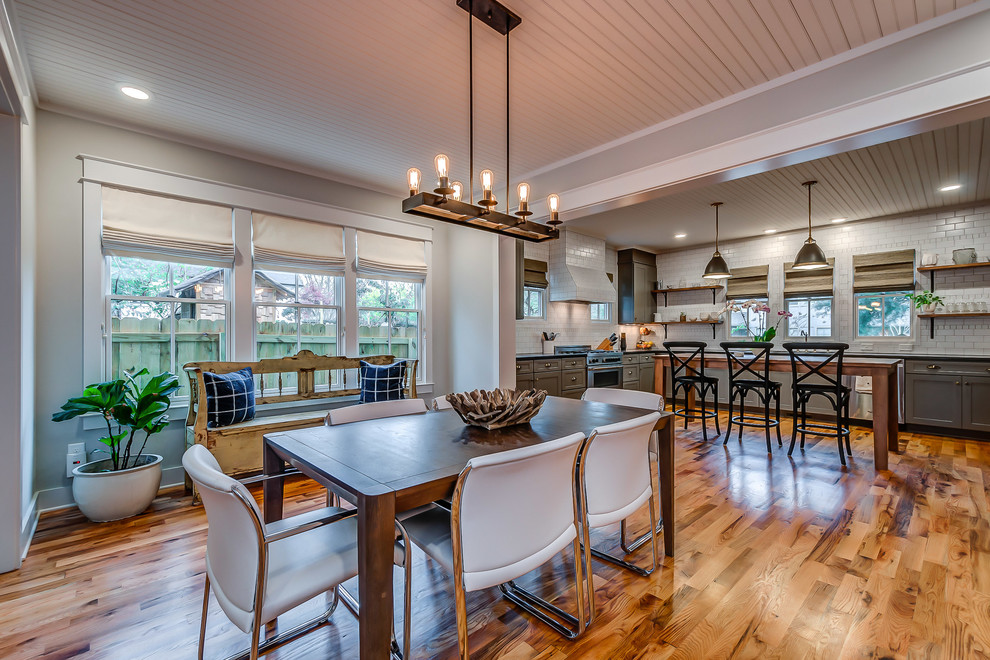 This is an example of a transitional kitchen/dining combo in Nashville with grey walls, medium hardwood floors and no fireplace.