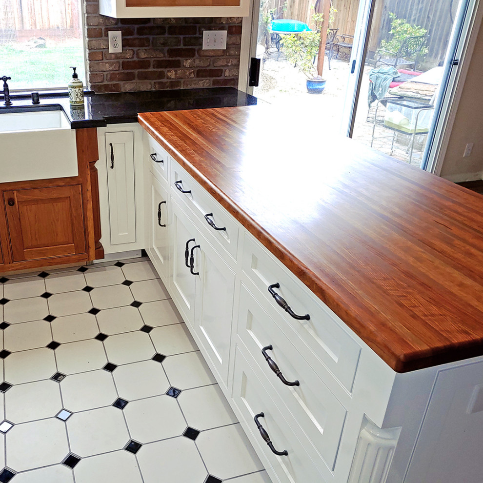 Example of a mid-sized transitional u-shaped cement tile floor eat-in kitchen design in Other with a farmhouse sink, recessed-panel cabinets, white cabinets, wood countertops, red backsplash, brick backsplash, stainless steel appliances, no island and red countertops