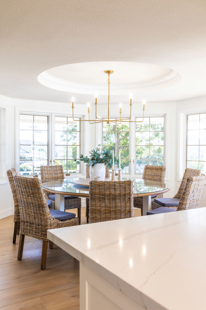 This is an example of a large modern dining room in San Diego with white walls, ceramic flooring and brown floors.