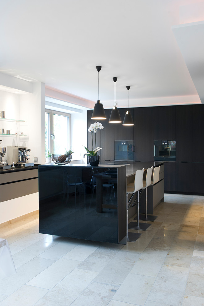 Inspiration for a large contemporary single-wall open plan kitchen in Other with flat-panel cabinets, black cabinets, granite benchtops, black appliances, porcelain floors, multiple islands and beige floor.