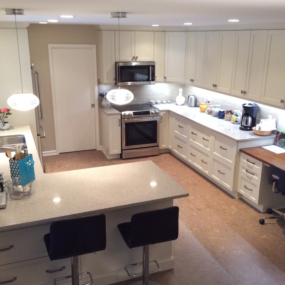 Inspiration for a transitional cork floor kitchen remodel in Edmonton with white cabinets, quartzite countertops, gray backsplash, ceramic backsplash and stainless steel appliances