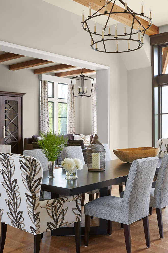 Inspiration for an expansive open plan dining in Minneapolis with beige walls, medium hardwood floors, a standard fireplace, a stone fireplace surround and brown floor.