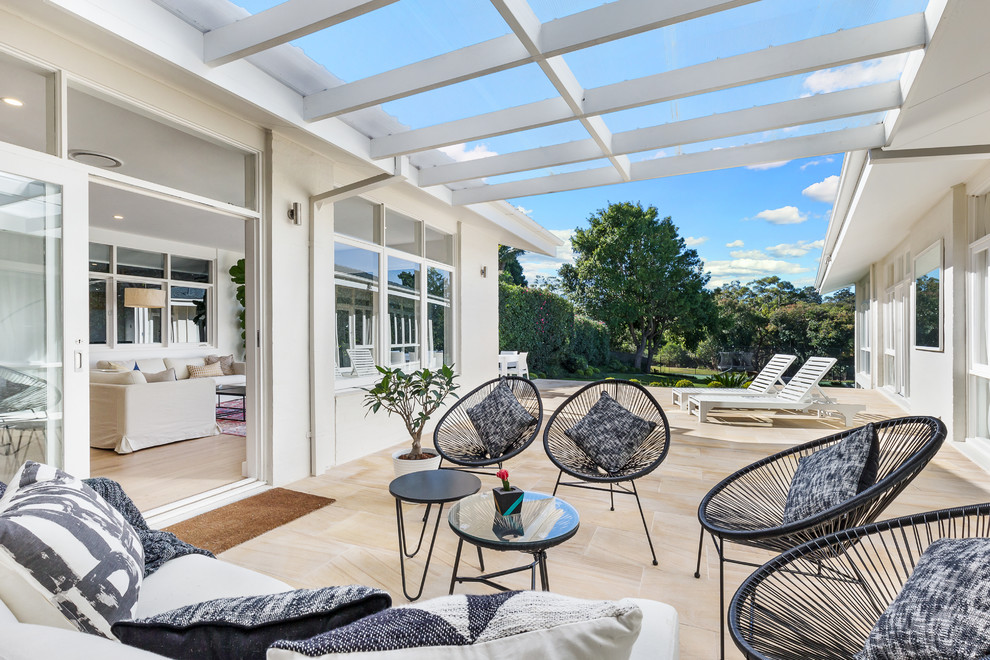 Design ideas for a contemporary patio in Sydney with natural stone pavers and a pergola.