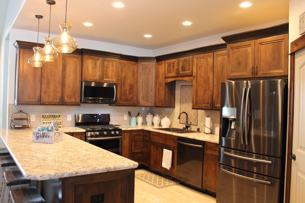 Transitional u-shaped porcelain tile eat-in kitchen photo with flat-panel cabinets, medium tone wood cabinets, laminate countertops, beige backsplash and stainless steel appliances