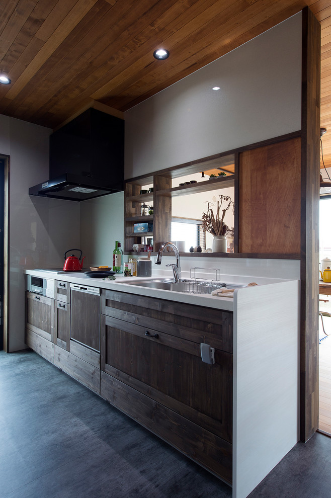 Inspiration for an industrial kitchen in Other with a single-bowl sink, recessed-panel cabinets, medium wood cabinets, white splashback and grey floor.
