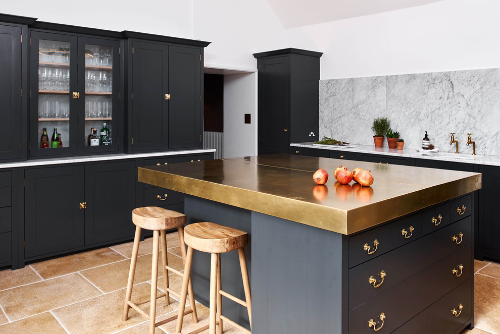 Contemporary l-shaped open plan kitchen in Gloucestershire with shaker cabinets, with island, an undermount sink, black cabinets, grey splashback, stone slab splashback and beige floor.