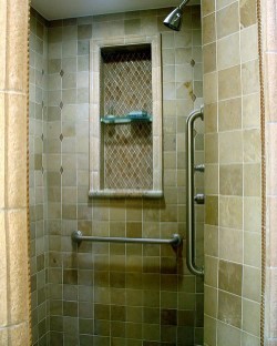 Corner shower - small traditional 3/4 brown tile and stone tile travertine floor corner shower idea in Houston with raised-panel cabinets, light wood cabinets, granite countertops and brown walls