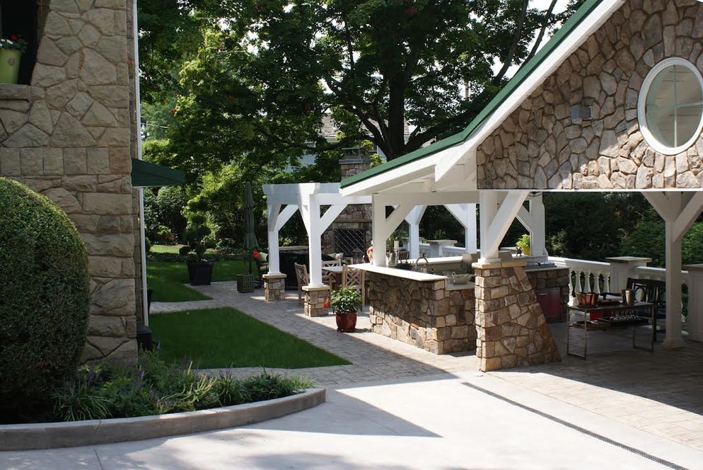 Large traditional backyard patio in Other with a fire feature, stamped concrete and a pergola.