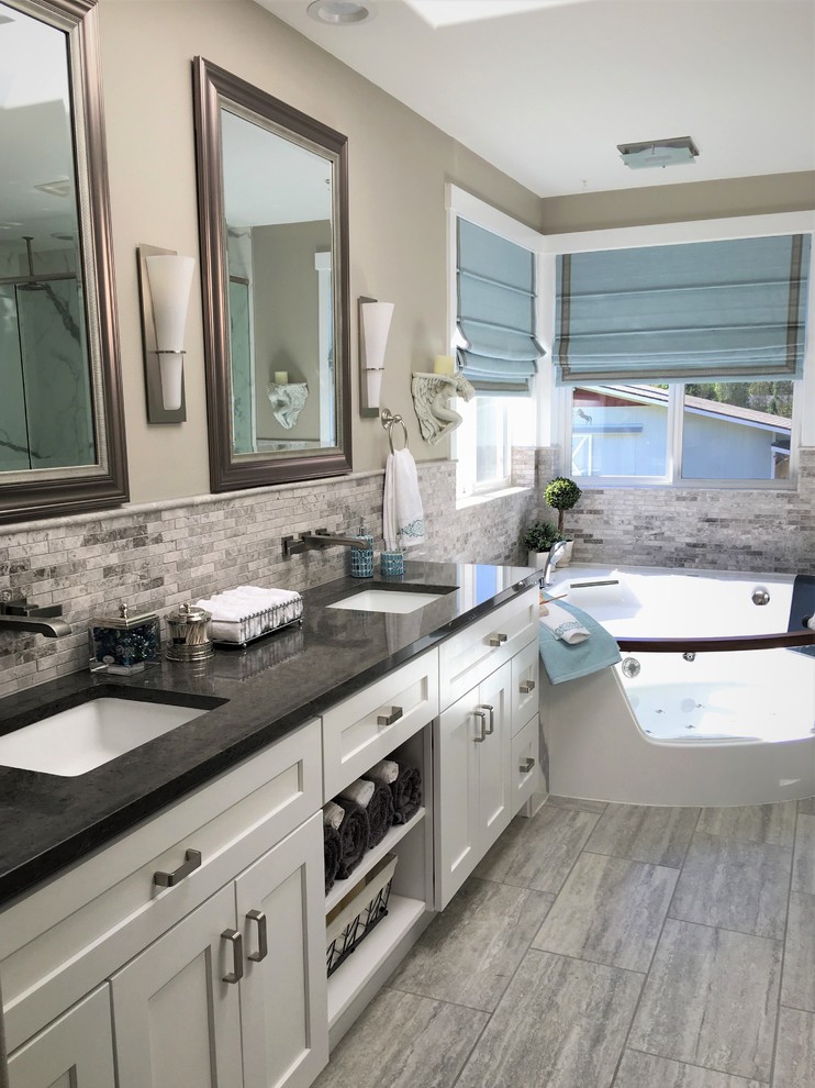 Design ideas for an arts and crafts master bathroom in Seattle with shaker cabinets, white cabinets, a corner tub, a corner shower, a one-piece toilet, gray tile, mosaic tile, grey walls, ceramic floors, an undermount sink, engineered quartz benchtops, grey floor and a hinged shower door.
