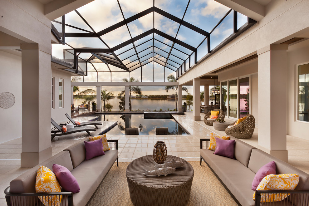 Example of a huge transitional backyard stone and custom-shaped infinity pool design in Tampa with a roof extension