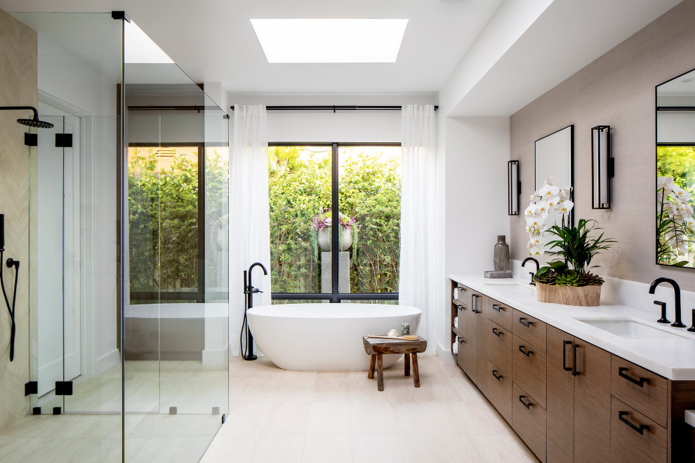 Photo of a large contemporary master bathroom in Orange County with flat-panel cabinets, dark wood cabinets, a freestanding tub, a curbless shower, white walls, limestone floors, engineered quartz benchtops, white floor, a hinged shower door, white benchtops, a double vanity and a built-in vanity.