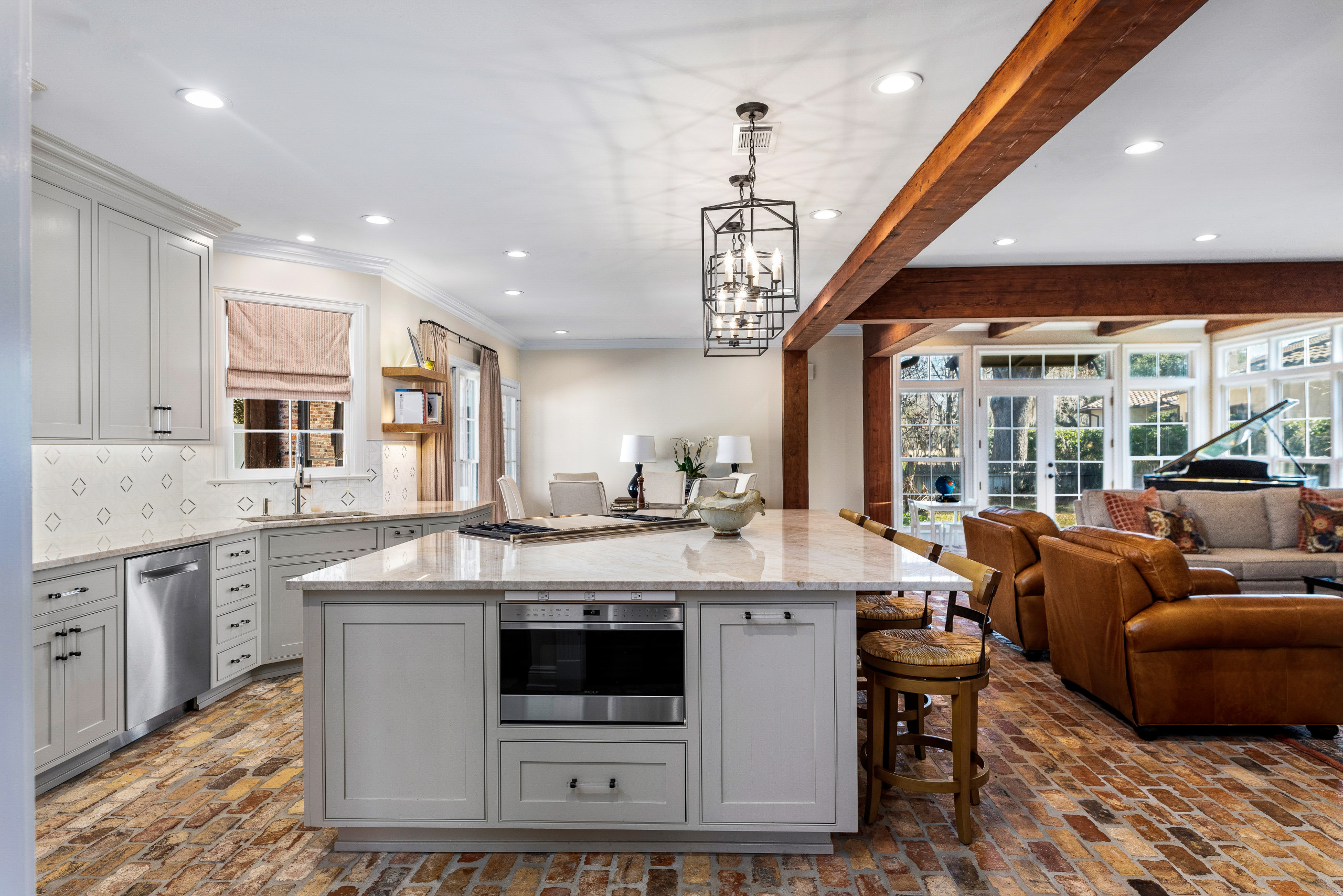 Inspiration for a mid-sized timeless l-shaped brick floor and brown floor open concept kitchen remodel in New Orleans with an undermount sink, recessed-panel cabinets, beige cabinets, quartzite counte