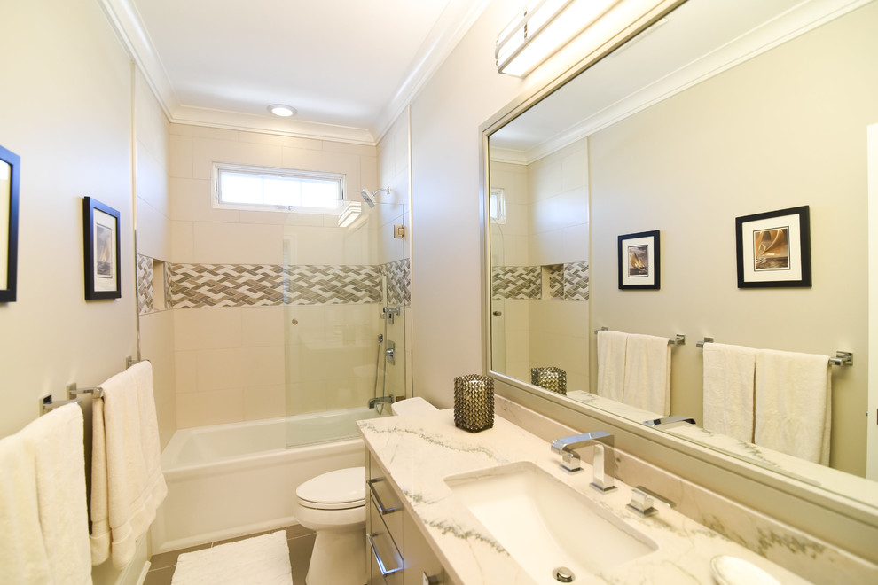 This is an example of a mid-sized transitional 3/4 bathroom in Philadelphia with flat-panel cabinets, beige cabinets, an alcove tub, a shower/bathtub combo, a two-piece toilet, beige tile, porcelain tile, beige walls, porcelain floors, an undermount sink, quartzite benchtops, brown floor, an open shower and white benchtops.