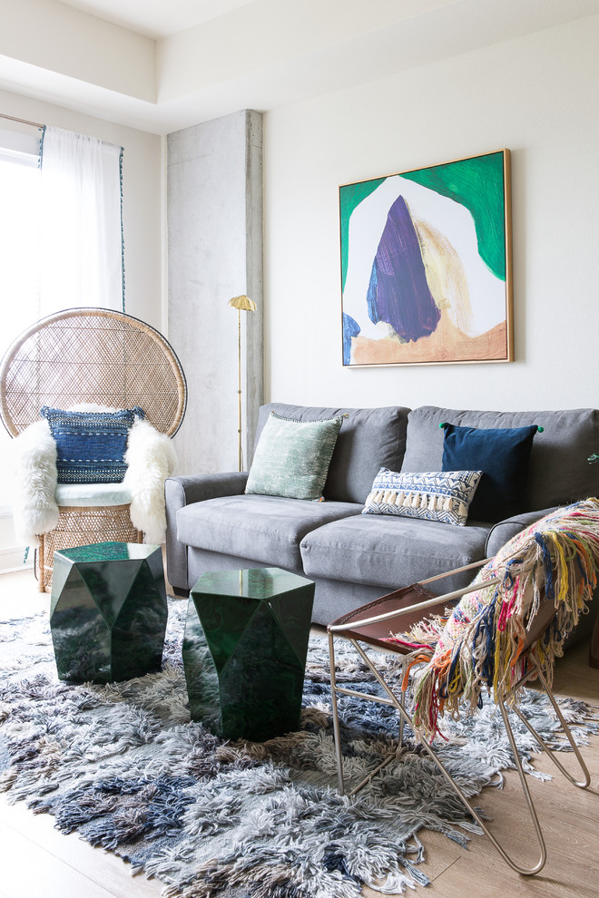 Example of an eclectic light wood floor living room design in New Orleans with white walls