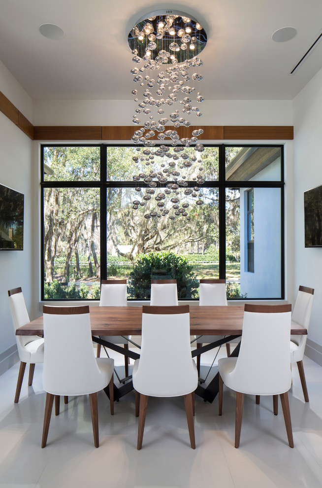 Photo of a mid-sized modern dining room in Orlando with white walls, porcelain floors, no fireplace and white floor.