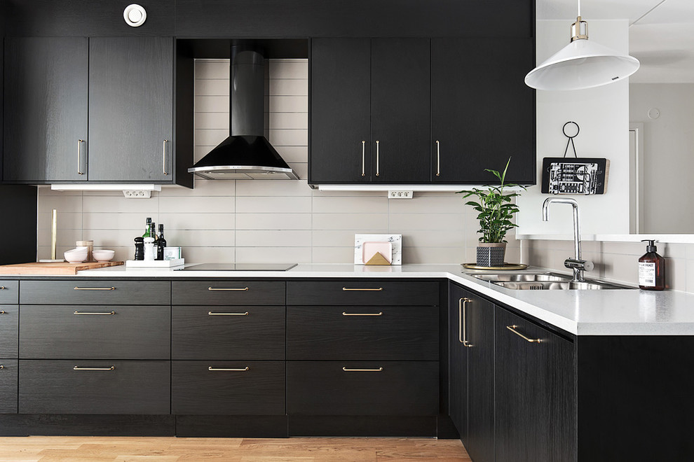 Photo of a mid-sized scandinavian l-shaped open plan kitchen in Stockholm with a double-bowl sink, flat-panel cabinets, beige splashback, medium hardwood floors and no island.