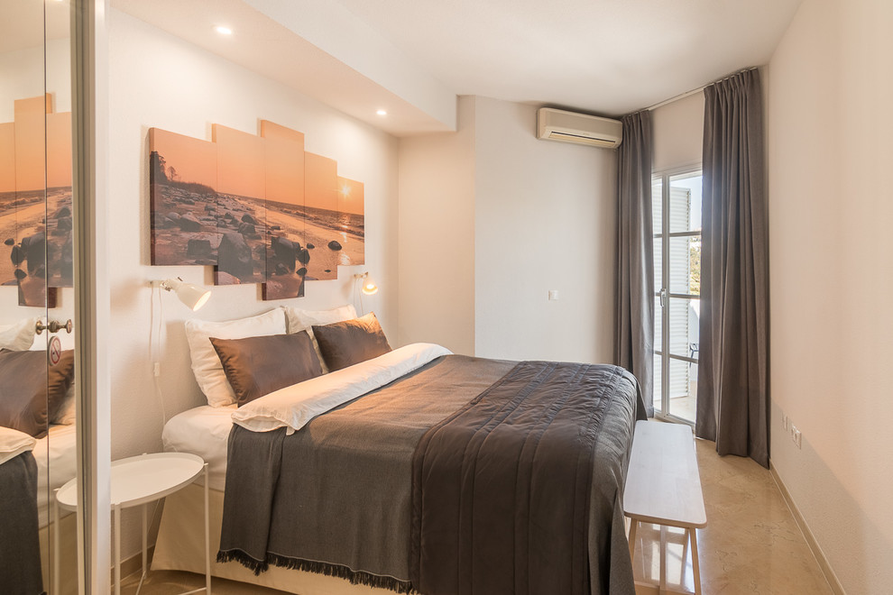 Modelo de dormitorio principal mediterráneo de tamaño medio con paredes blancas, suelo de baldosas de porcelana y suelo beige