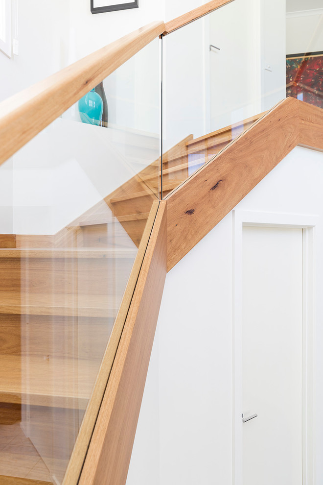 Inspiration for a large contemporary wood u-shaped staircase in Melbourne with wood risers.