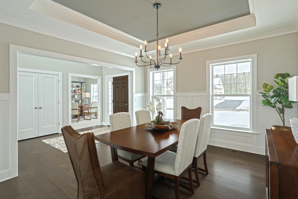 Large mid-century modern dark wood floor and tray ceiling enclosed dining room photo in Other