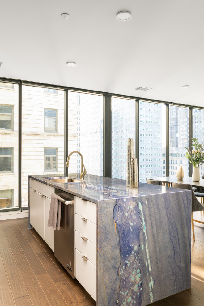 Exemple d'une cuisine moderne avec un évier encastré, un placard à porte plane, un plan de travail en quartz, une crédence bleue, îlot et un plan de travail bleu.