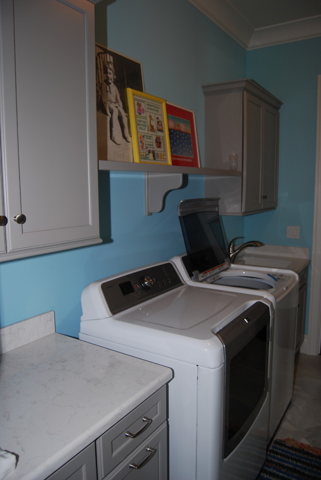 Photo of a mid-sized contemporary dedicated laundry room in Cincinnati with an utility sink, recessed-panel cabinets, grey cabinets, blue walls and a side-by-side washer and dryer.