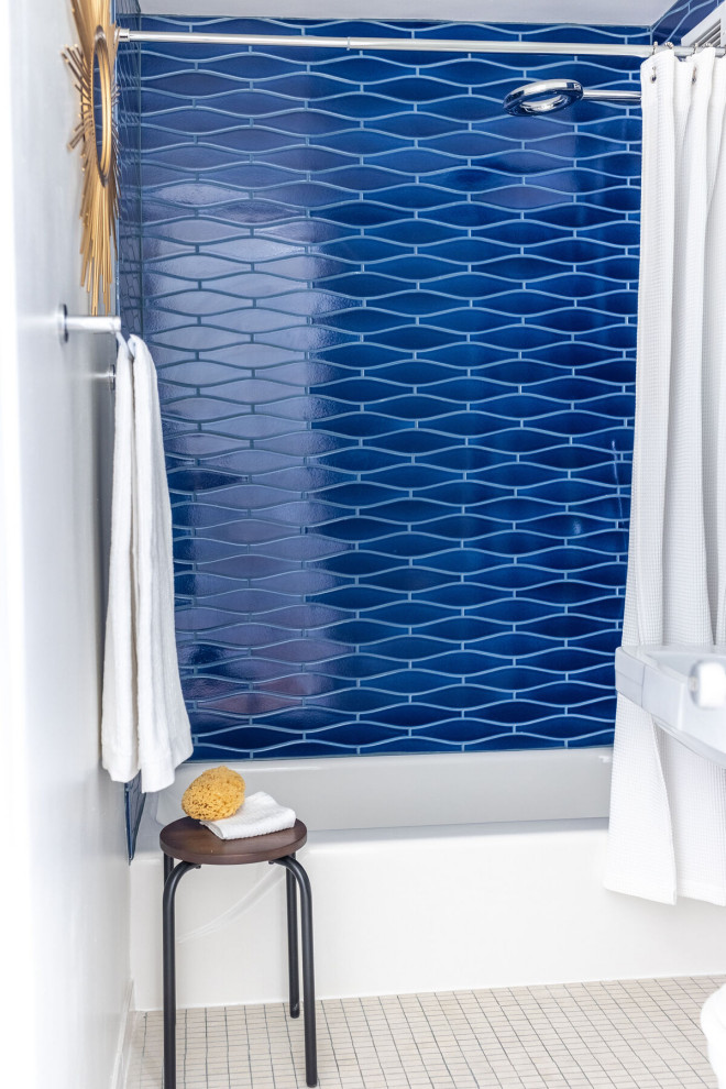 Exemple d'une salle d'eau bord de mer de taille moyenne avec une baignoire posée, un carrelage bleu, des carreaux de céramique et un mur blanc.