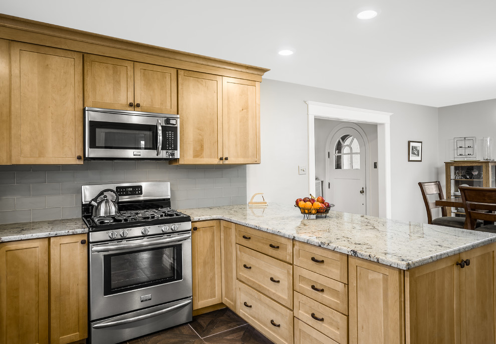 Photo of a mid-sized arts and crafts u-shaped eat-in kitchen in Philadelphia with an undermount sink, shaker cabinets, light wood cabinets, granite benchtops, glass tile splashback, grey splashback, black appliances, linoleum floors and a peninsula.